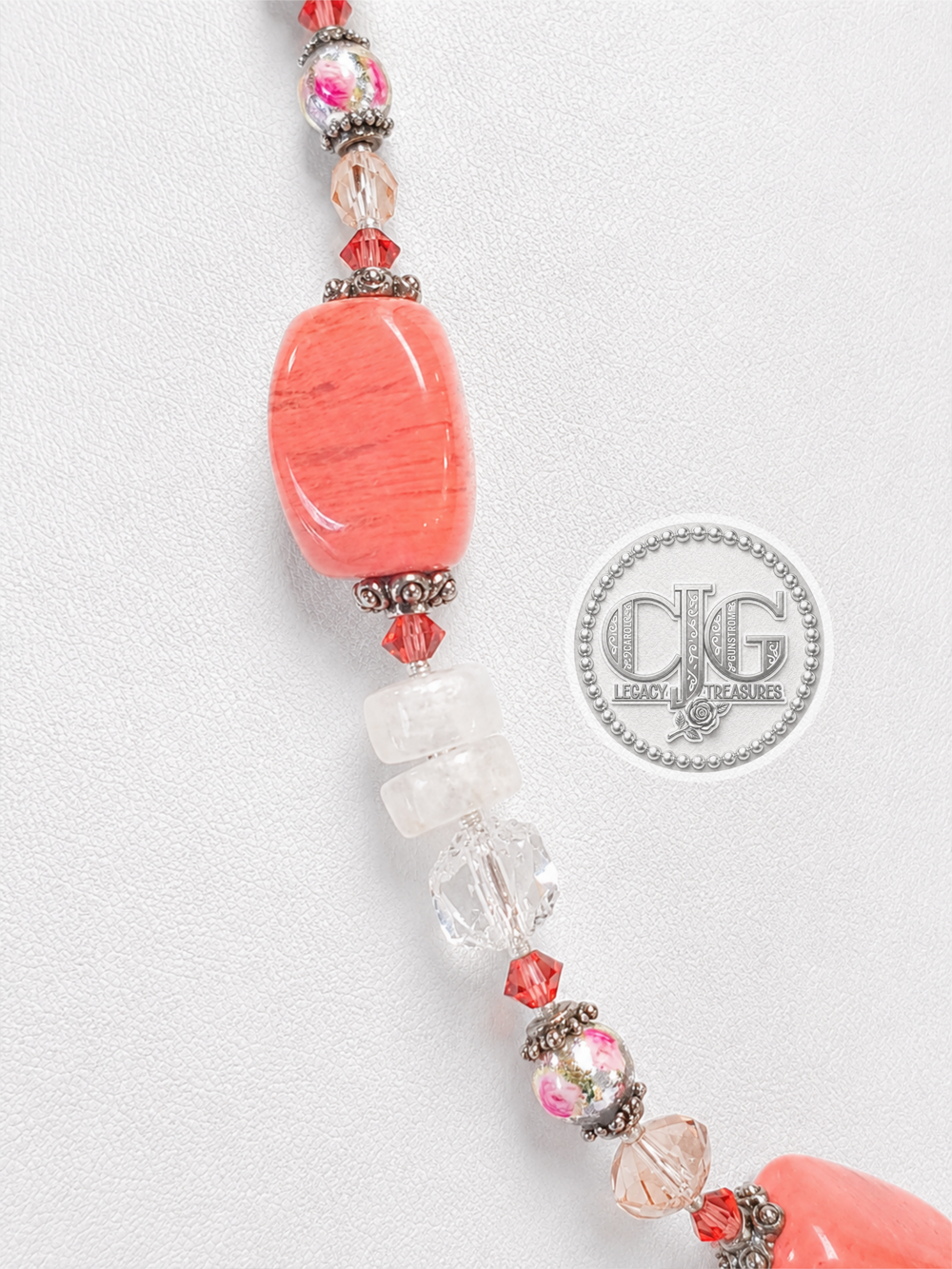 Macro close-up of chunky coral barrel bead with antique silver Bali spacers and crystal bicones