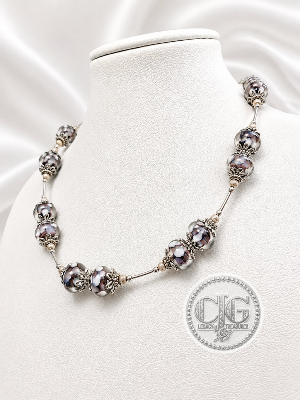 Midnight Bloom necklace draped on white jewelry bust, front view