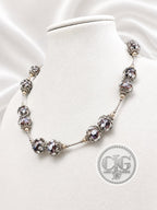 Midnight Bloom necklace draped on white jewelry bust, front view