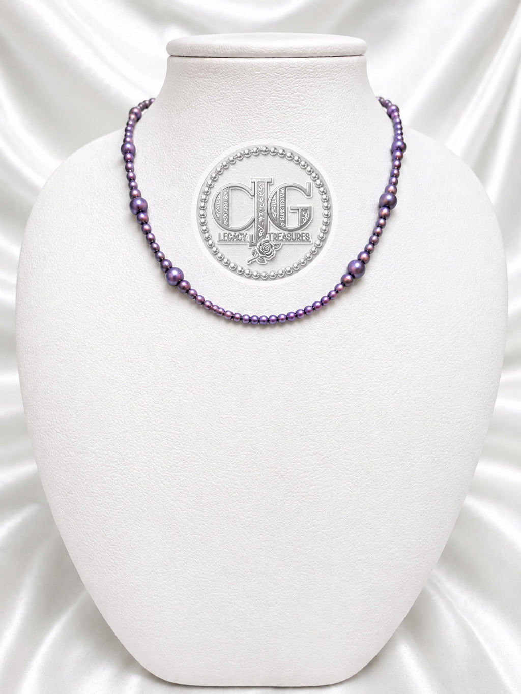 Violet pearl necklace displayed on white jewelry bust