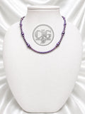 Violet pearl necklace displayed on white jewelry bust