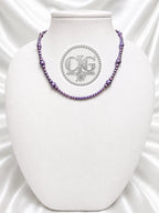 Violet pearl necklace displayed on white jewelry bust