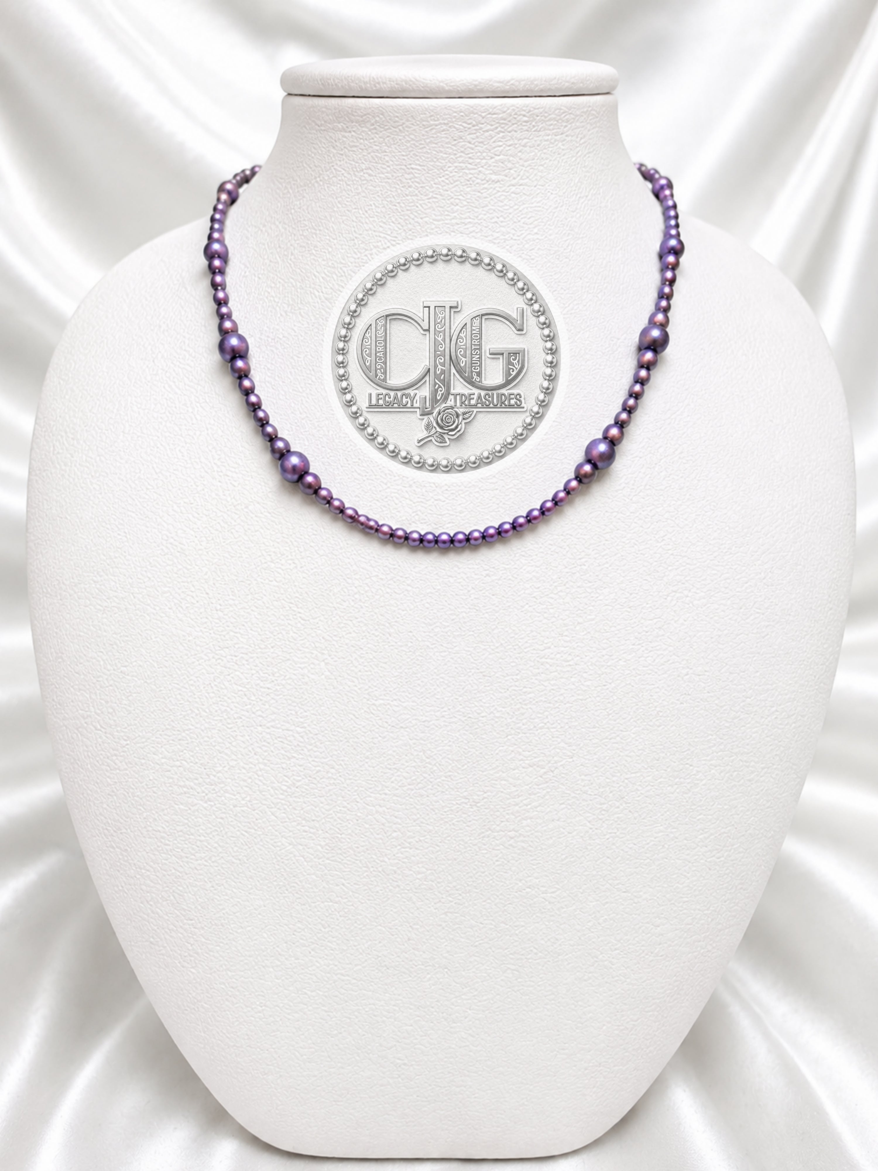 Violet pearl necklace displayed on white jewelry bust