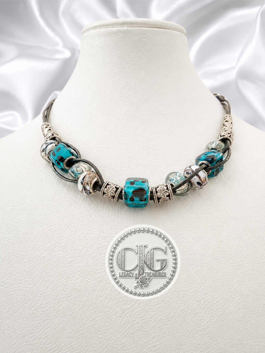 Teal leopard lampwork necklace displayed on CJG branded black card with lobster claw clasp detail