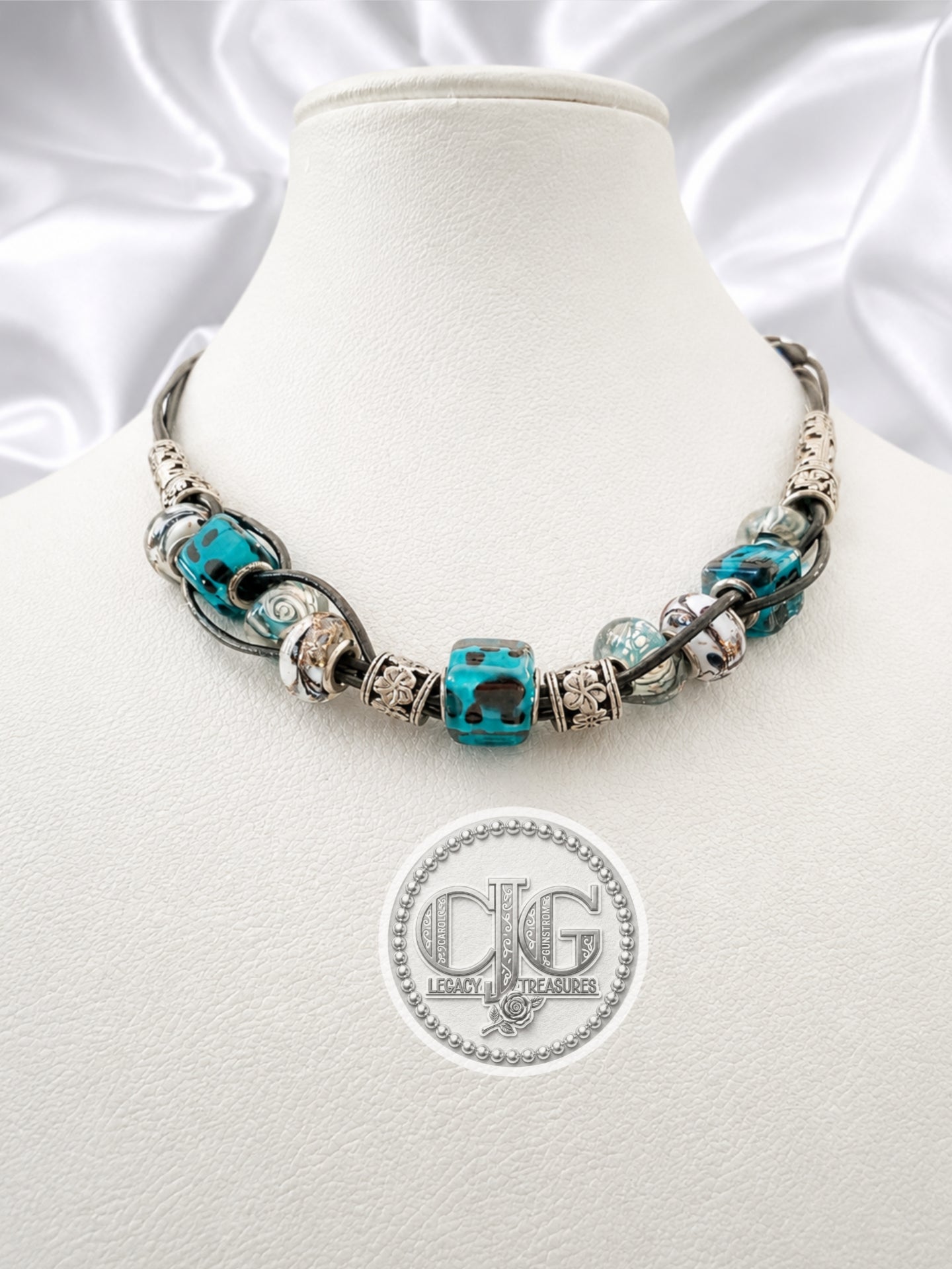 Teal leopard lampwork necklace displayed on CJG branded black card with lobster claw clasp detail