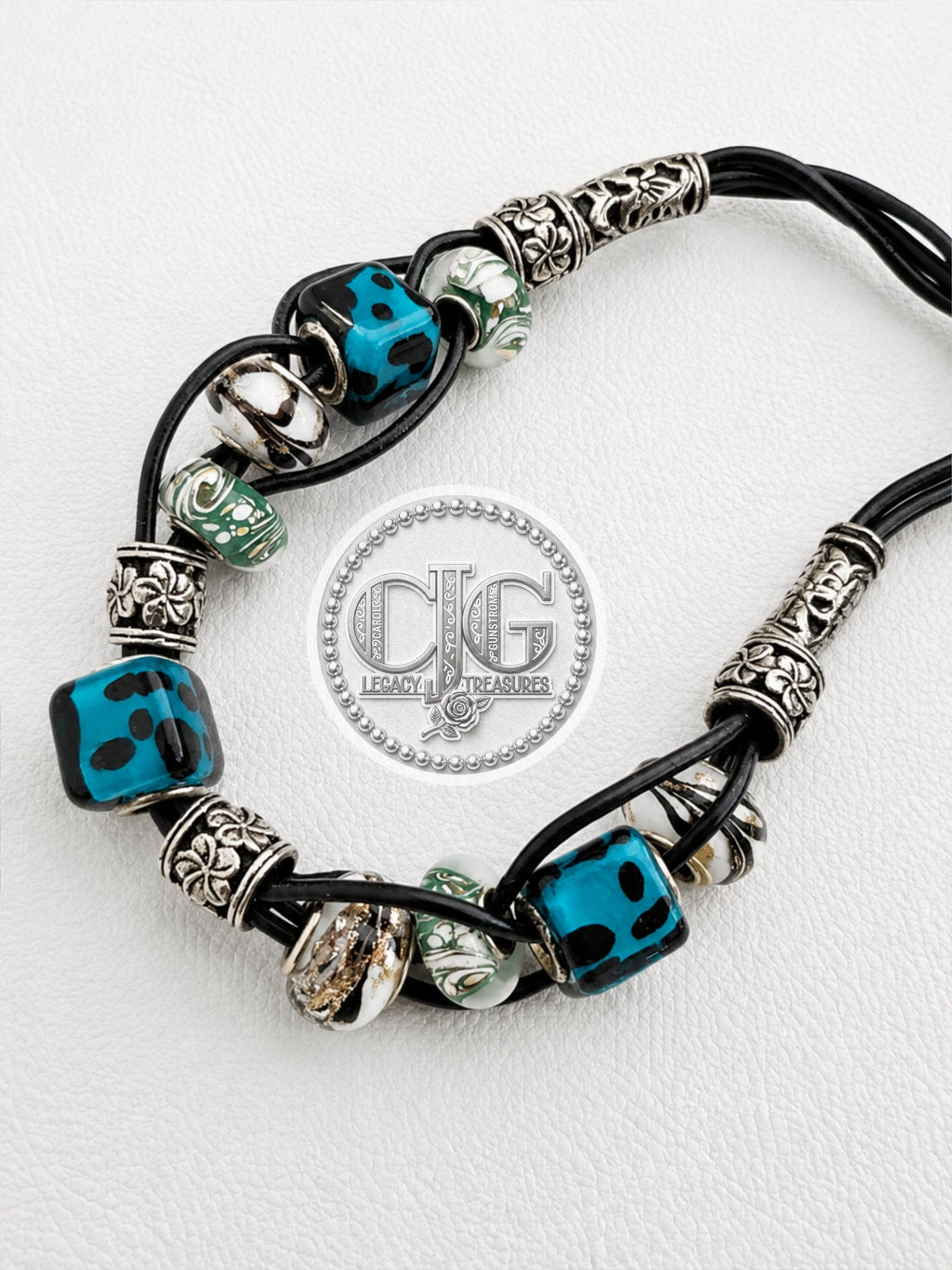Full view of teal leopard lampwork woven braid necklace with silver accents